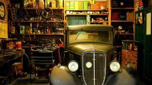 A garage with an old car and a lot of tools. During a move, it will not be easy to pack your garage because it is not clutter-free.
