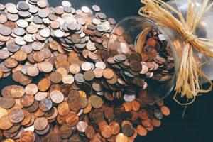 Coins spilling out of a jar. Affordable movers in Toronto will save you from having to dig into your piggy bank.