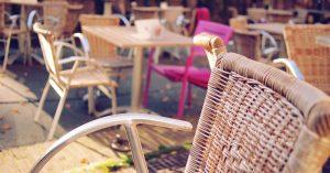 A few brown chairs and a pink chair in a restaurant.